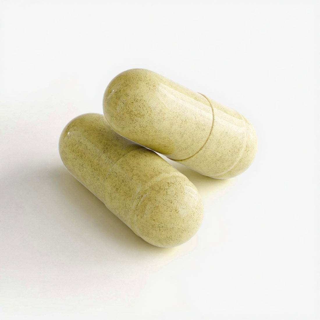 Two green capsules on a white background
